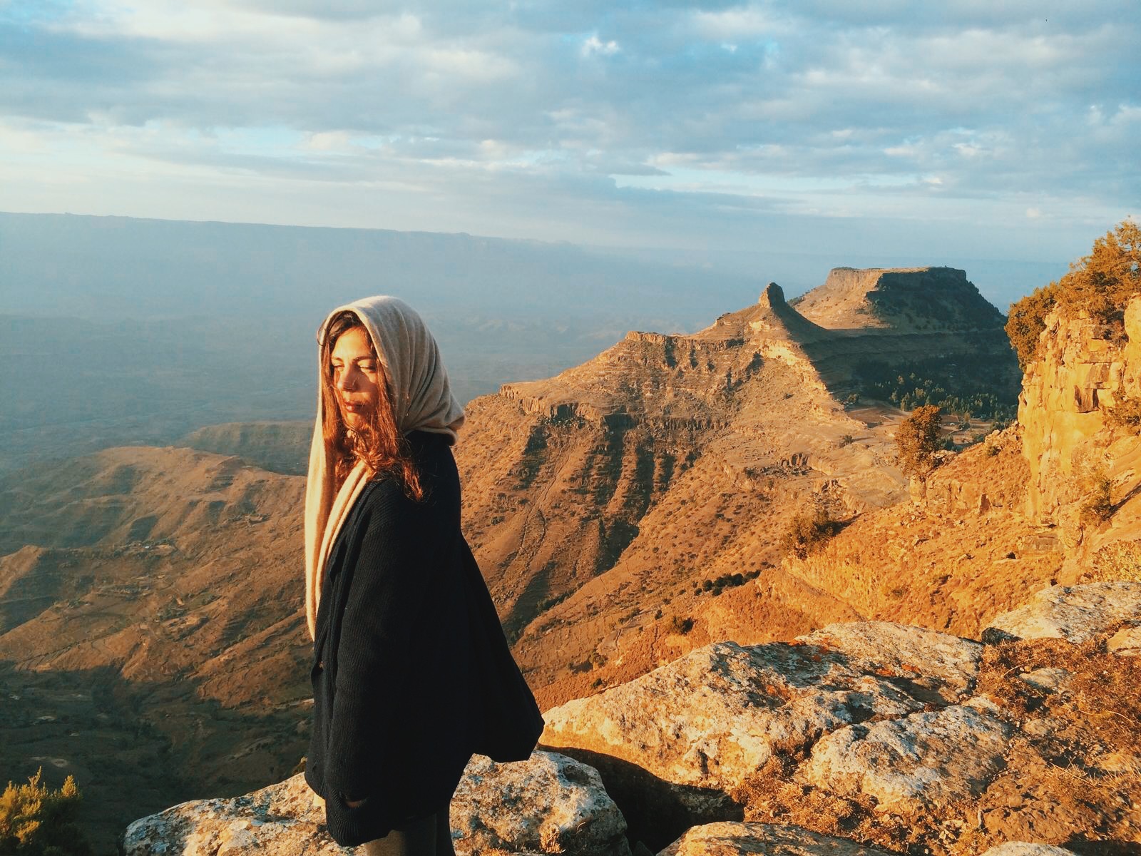 An image of Tania Feghali standing on top of a huge mountain in the sun 